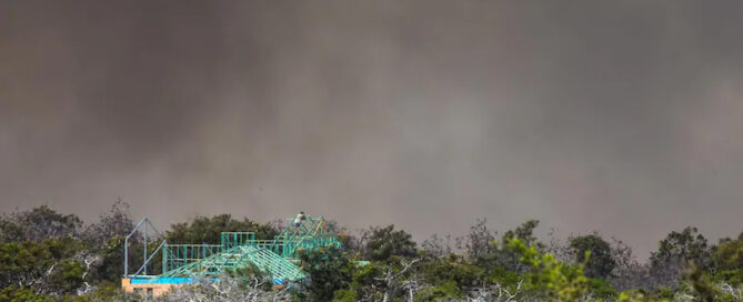 A man watches the bushfire from the roof of his partly completed home in Tranquil Drive, Esperance. Credit: The West Australian, Mogens Johansen, The West Australian