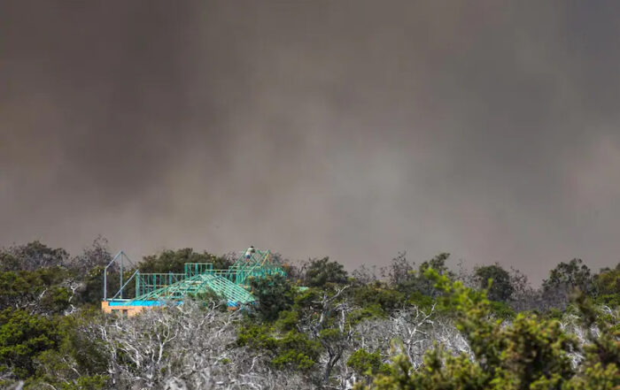 A man watches the bushfire from the roof of his partly completed home in Tranquil Drive, Esperance. Credit: The West Australian, Mogens Johansen, The West Australian