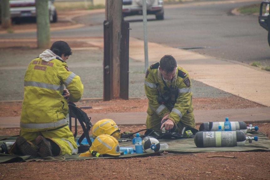 Firefighters change over oxygen tanks at a house fire in Kalgoorlie-Boulder.(ABC Goldfields-Esperance: Jarrod Lucas)